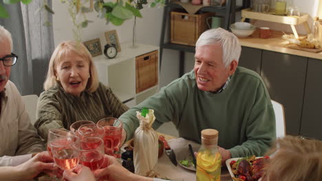Gesellschaft-älterer-Freunde,-Die-Beim-Abendessen-Zu-Hause-Gläser-Anstoßen